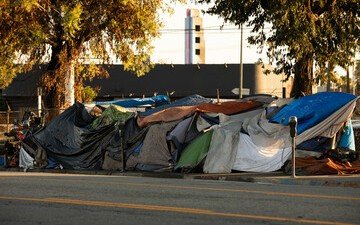 A row of tents forming an encampment beside a city street